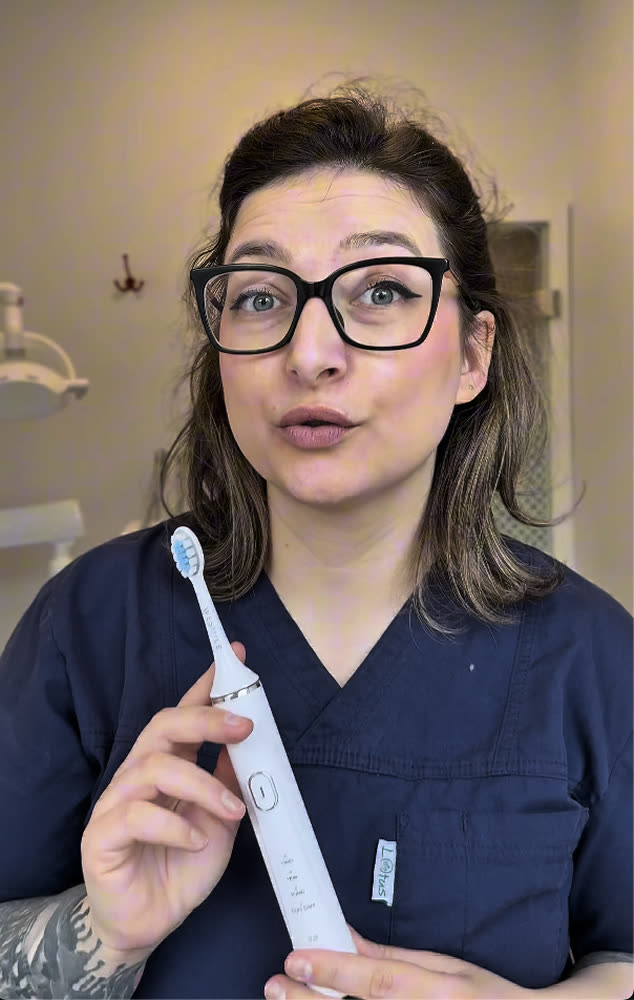Denisa Romanescu, dental hygienist, holding the WeSmile sonic toothbrush in her clinic